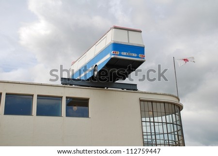 BEXHILL-ON-SEA, ENGLAND - SEPTEMBER 12: A life size replica of a coach, by British artist Richard Wilson, hangs off the roof of the De La Warr Pavilion on September 12, 2012 at Bexhill-on-Sea, Sussex.