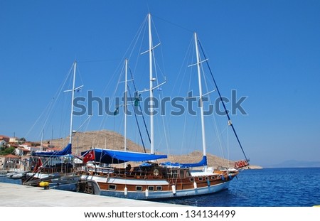 HALKI, GREECE - JUNE 14: Turkish registered tourist boats moored in Emborio harbour on June 14, 2010 on Halki island, Greece. With a population of less than 300 people, Halki is dependent on tourism.