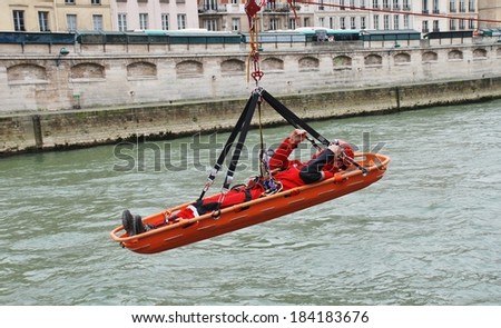 PARIS, FRANCE - MARCH 18, 2014: Firefighters of the elite GRIMP unit carry out a training exercise at the Pont Saint Michel on the River Seine. The unit specialises in rescues in hazardous situations.