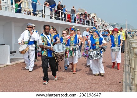 ST.LEONARDS-ON-SEA, ENGLAND - JULY 12, 2014: Dende Nation, Samba drum troupe, perform during a parade on the seafront at the annual St.Leonards Festival. The community event was first held in 2006.