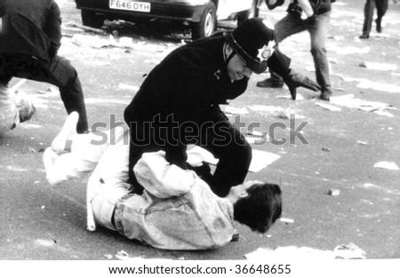 LONDON-MARCH 31: A British police officer grapples with a protester during the Poll Tax Riots on March 31, 1990 in Trafalgar Square, London.