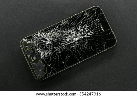 KAUNAS, LITHUANIA - DECEMBER 22, 2015: Broken screen iphone 4, black background