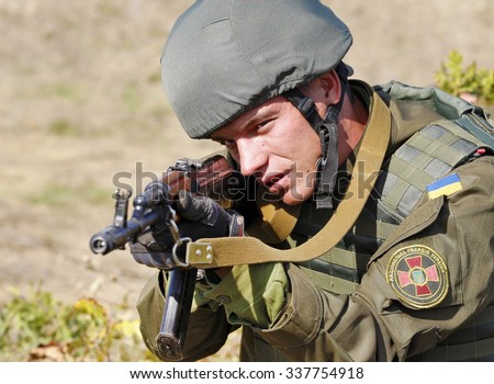 KIEV REGION, UKRAINE - October 02, 2015: A serviceman takes aim from the AK-47 gun during a training session at  the Ukrainian National Guard training center,in Stare, Ukraine, 02 October 2015.