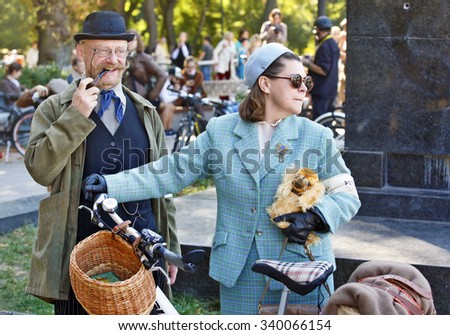 KIEV,UKRAINE - OCT. 04, 2015: Elderly couple dressed in vintage clothes with their bikes attend  a retro parade on bicycles \