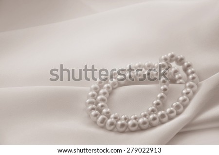 Elegant beige background with lace, silk and pearls