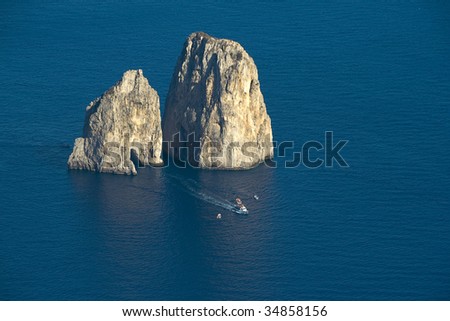 Ship bypassing giant rocks in the sea near island of Capri, Italy