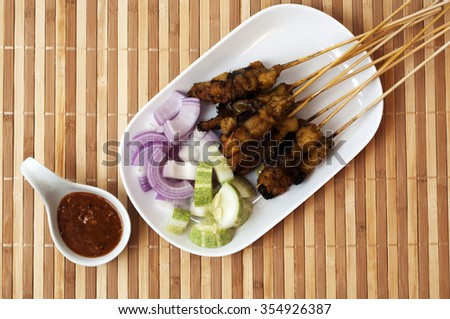 Fresh chicken satay on bamboo mat, one of famous Malaysian local dishes.