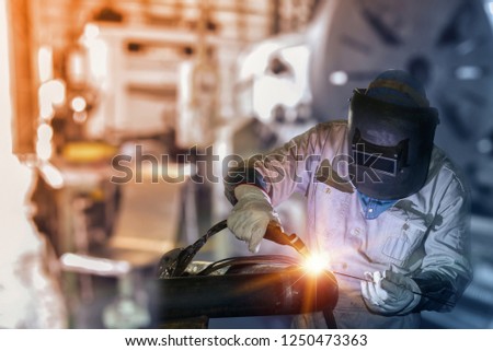 Industry worker at the factory welding metal steel pipe by TIG weld torch gas argon  on Dark tone