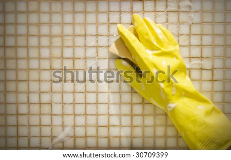 Hand in rubber glove washing the wall