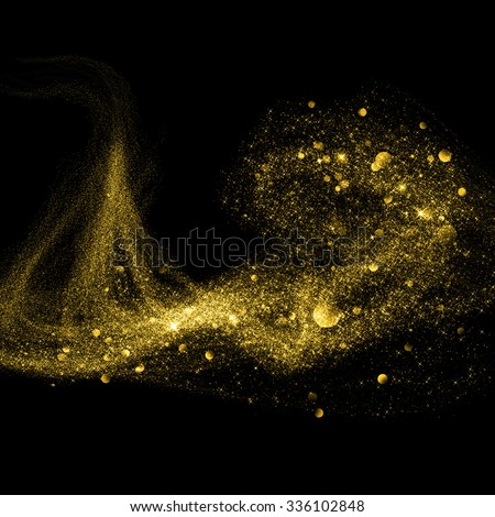 Gold glittering stars dust trail on black background