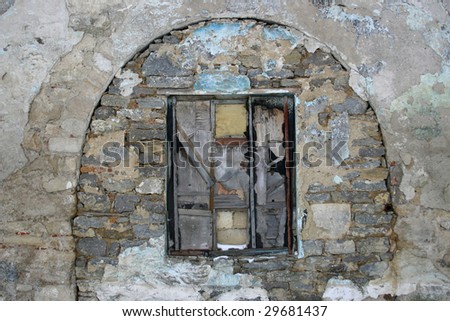 Stock photo  of a grey old stone wall with a  closed narrow  window in the middle of it Stock photo of an old brown brick wall with a  narrow window  in the middle of it