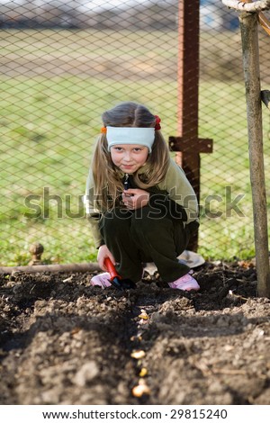 stock photo A pretty little girl squatting down on the ground in her 