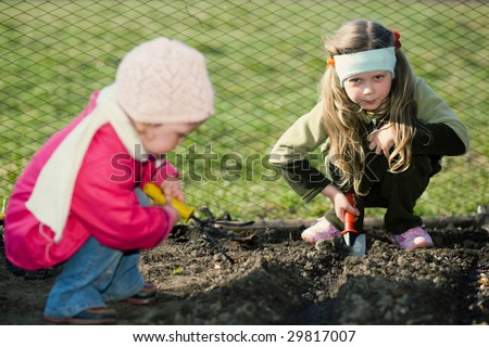 stock photo Two pretty little girls squatting down on the ground