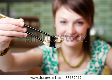 An image of a nice woman eating sushi