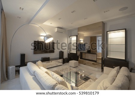 White modern apartments in the evening with fireplace and air conditioning and TV