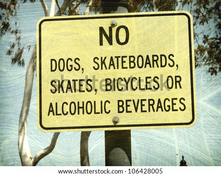 aged and worn vintage photo of  no skateboards or dogs sign