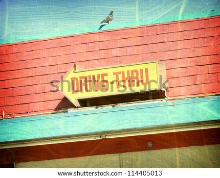 aged and worn vintage photo of drive-thru sign and pigeon