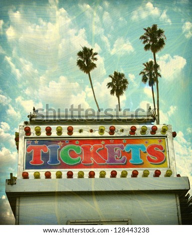 aged and worn vintage carnival ticket booth with palm trees