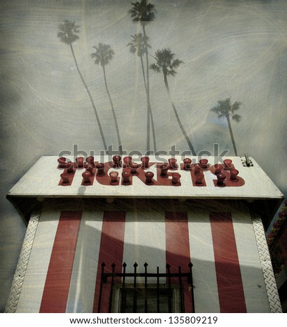 aged and worn vintage photo of  ticket booth with palm trees
