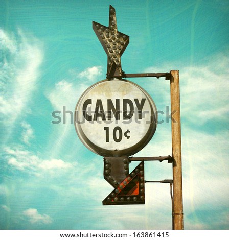 aged and worn retro photo of candy ten cents sign with bulbs and arrow