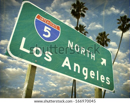 aged and worn vintage photo of los angeles sign with palm trees