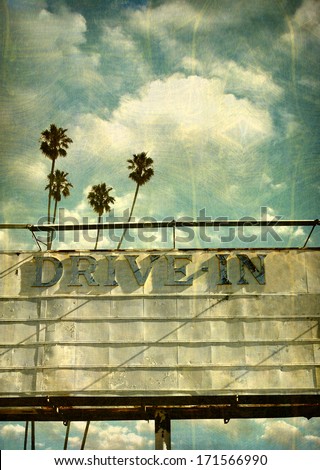 Aged And Worn Vintage Photo Of Retro Drive In Movie Marquee With Palm Trees
