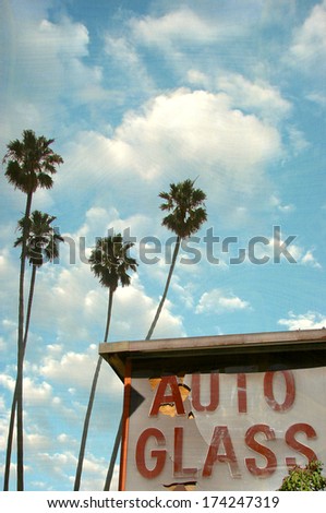 aged and worn photo of auto glass sign with palm trees