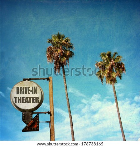 aged and worn vintage photo of  drive in theater sign with palm trees