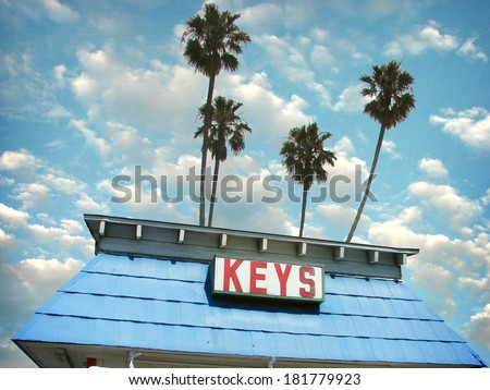 aged and worn vintage photo of key shop with palm trees