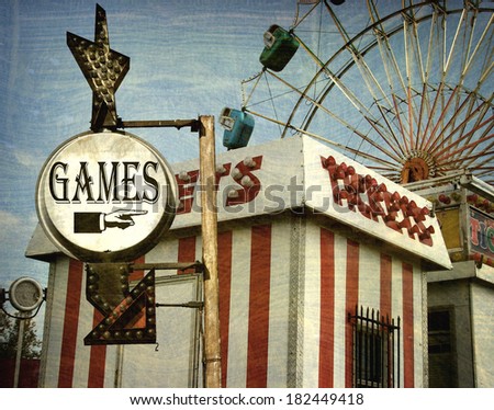 aged and worn vintage photo of carnival games sign with ferris wheel