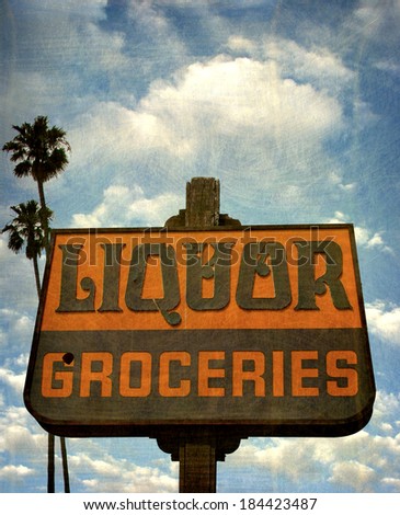aged and worn vintage photo of liquor and groceries sign with palm trees