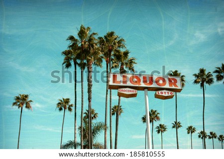 aged and worn vintage photo of liquor and groceries store sign with palm trees