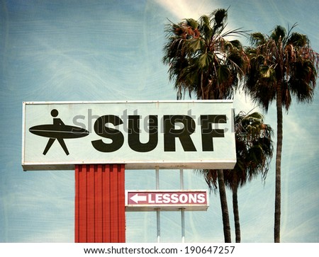 aged and worn vintage photo of surf lessons sign on beach