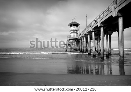 black and white photo of ocean pier with small waves
