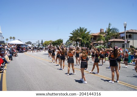 HUNTINGTON BEACH, CA - JULY 4: Huntington Beach High School cheerleaders perform during Huntington Beach July 4th parade.