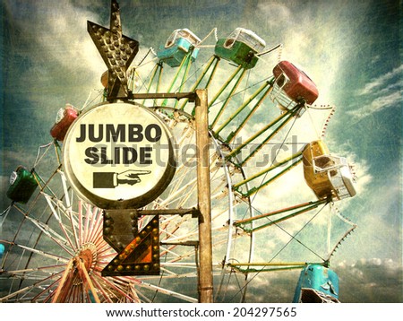 aged and worn vintage photo of jumbo slide ride sign at carnival