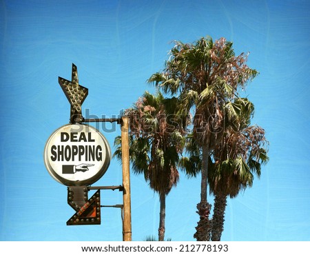 aged and worn vintage photo of deal shopping sign with palm trees