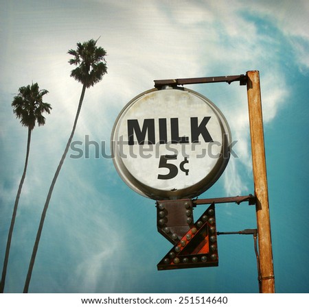 aged and worn vintage photo of five cent milk sign with palm trees