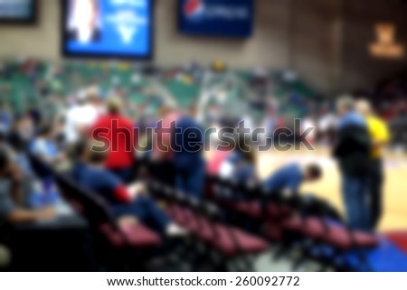 blurred background of basketball crowd in arena court side seats