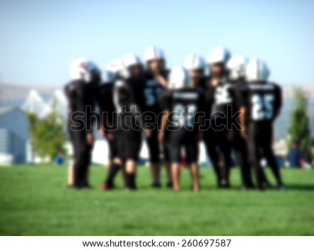 blurred background with youth american football players in action