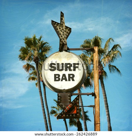 aged and worn vintage surf bar sign with palm trees