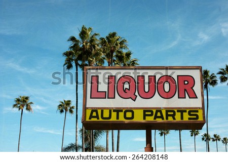 aged and worn vintage photo of liquor and auto parts sign with palm trees