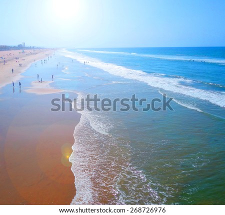 beach with sand and waves and bright sun flare