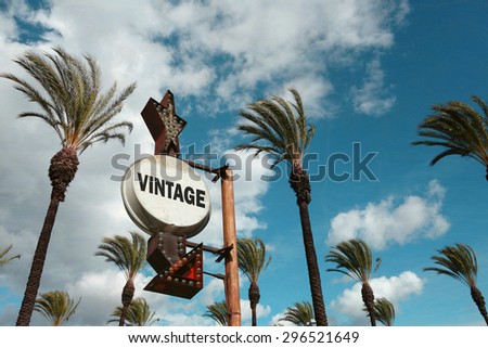 aged and worn vintage photo of vintage sign with palm trees