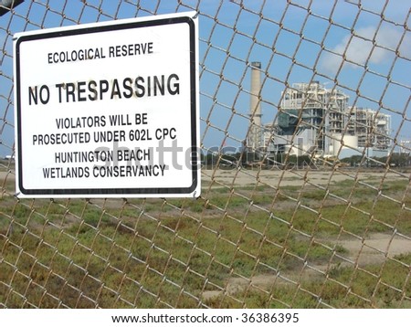 ironic ecological preserve sign with industrial factory in background