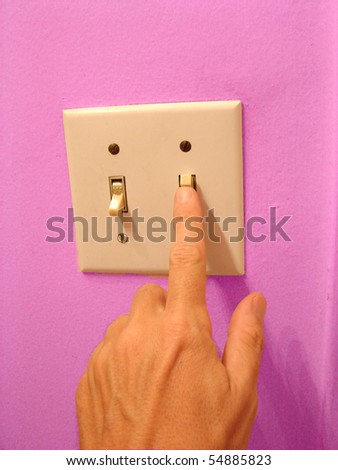 hand flipping light switch with pink wall