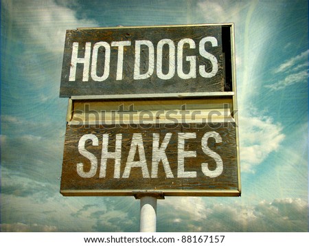 aged and worn vintage photo of old retro diner hot dogs and shakes sign