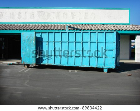 blue trash dumpster on construction site