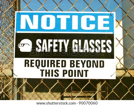 aged and worn vintage photo of safety glasses required sign
