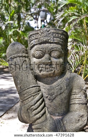 a south pacific statue with a palm grove background on a sunny island